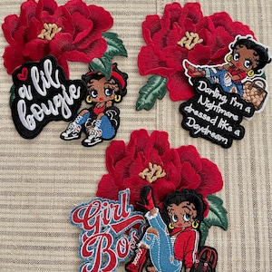 May include: Embroidered patches featuring a cartoon woman with red and black accents, paired with red floral designs. The patches include text that reads "a lil bougie", "Darling, I'm a Nightmare dressed like a Daydream", and "Girl Boss".
