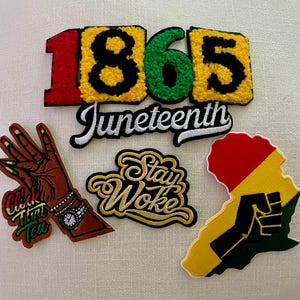 May include: A collection of embroidered patches with themes of Black history and culture. The patches include the number "1865", the word "Juneteenth", a hand with a watch, the phrase "Stay Woke", and an outline of Africa with a raised fist.