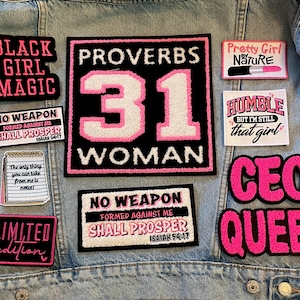May include: A denim jacket adorned with various embroidered patches. The patches feature phrases like "Black Girl Magic," "Proverbs 31 Woman," and "CEO Queen," along with other inspirational quotes and designs in pink and black.