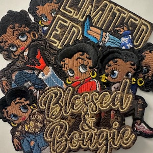 May include: A collection of embroidered patches featuring a cartoon woman with large eyes, gold hoop earrings, and a black hairstyle. Some patches have the text "LIMITED EDITION" and "Blessed & Bougie" in gold thread.
