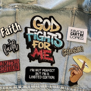 May include: Light blue denim jacket adorned with various embroidered patches. Patches include the words "Faith", "God Fights For Me", "Favor Can't Be Copied", "Chosen", and "Limited Edition". A patch with a hand and lips is also present.