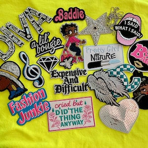 May include: A collection of assorted embroidered and rhinestone patches featuring various designs including the words DIVA, Baddie, I SAID WHAT I SAID, Pretty Girl by NATURE, Expensive And Difficult, Fashion Junkie, and cried but DID THE THING ANYWAY.