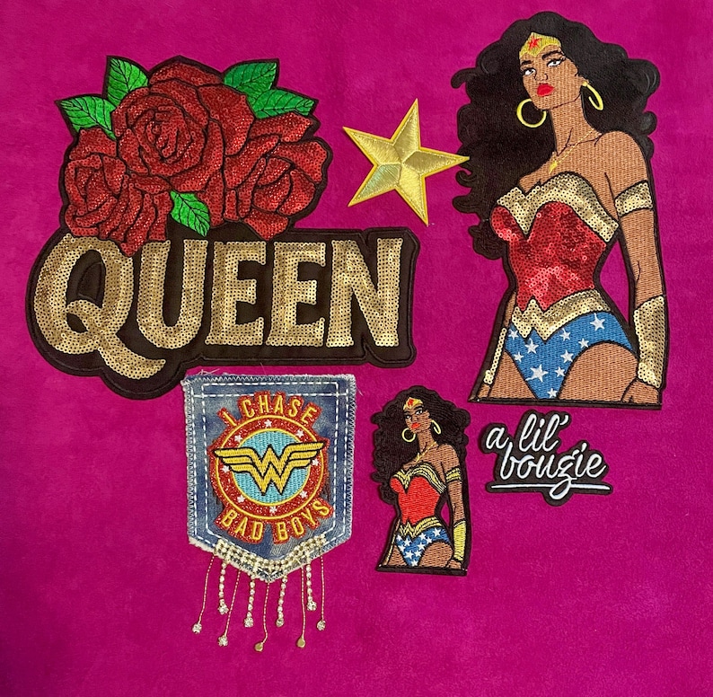 May include: A collection of embroidered patches featuring a large red rose cluster above the gold sequined text QUEEN, a gold star, a large Wonder Woman figure, a denim pocket patch with the text I CHASE BAD BOYS, a small Wonder Woman, and a lil' bougie text.