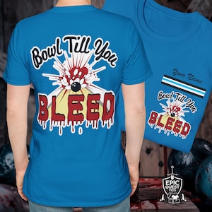 以下が含まれることがあります： ボウリングのピンが描かれた青いTシャツで、"Bowl Till You Bleed"という文字が書かれています。