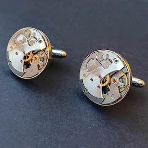 May include: A handmade wooden sign displaying the word "Welcome" in a handwritten font. The sign is painted white with a distressed finish, and a small green leaf is attached. Ideal for home decor.