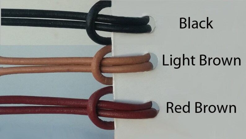 May include: Three leather cords in black, light brown, and red brown colors. The cords are tied in a knot and are displayed on a white background with the color names written next to them.