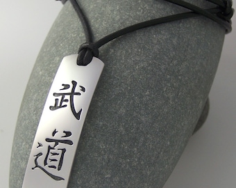 Collar Budo Kanji - Colgante de artes marciales de acero inoxidable con correa de cuero natural ajustable.