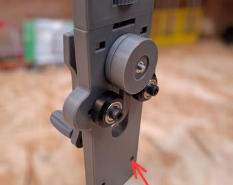 Könnte beinhalten: Ein grauer 3D-gedruckter Bunddrahtbender mit einem Knopf oben und zwei Befestigungspunkten unten. Der Text "Fret Wire Bender" ist oben im Bild in Grün gedruckt.