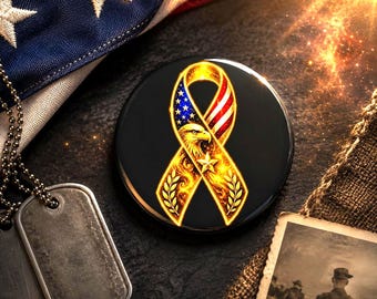 May include: A circular black pin with a gold ribbon design, incorporating red, white, and blue elements. The ribbon features an eagle, stars, and laurel leaves. An American flag, dog tags, and a vintage photo are in the background.