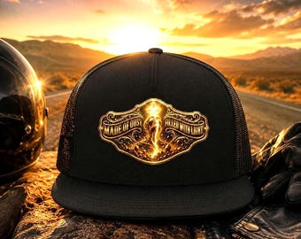 May include: Black trucker hat with a gold emblem reading "MADE OF DUST FILLED WITH LIGHT". The hat features a mesh back and a curved peak. The background shows a sunset over a desert road, with a motorcycle helmet and leather jacket.