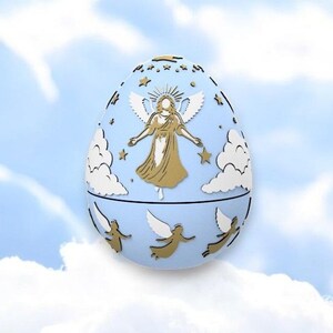 May include: A light blue decorative egg with a gold angel design, white clouds, and gold stars. The egg has a hinged design and is set against a cloudy sky background. The egg is a decorative item.