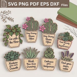 Op de afbeelding: Een verzameling van acht houten plantvormen met diverse vetplanten en cactussen in potten. Elk stuk bevat een unieke inspirerende tekst zoals Go with the Flow, Stay Strong, Bloom Often, Find Beauty in Togetherness, Nurture your own Growth, Heal, then Keep Growing, Embrace your Uniqueness en Find your inner calm.
