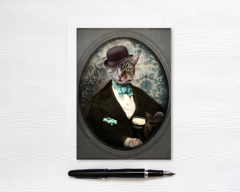 Puede incluir: Un retrato de un gato con un sombrero bomb&iacute;n negro y una corbata de lazo turquesa, sosteniendo un vaso de cerveza Guinness. El gato est&aacute; vestido con un traje negro con una camisa blanca y un pa&ntilde;uelo de bolsillo. El retrato est&aacute; enmarcado en un marco ovalado negro con un fondo gris.