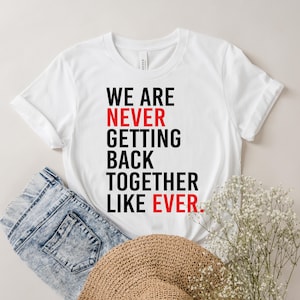 Może przedstawiać: Biała koszulka z czarnym napisem "We are never getting back together like ever." Słowo "never" jest czerwone.