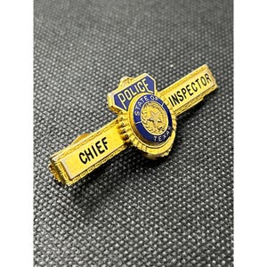 May include: A gold-colored police badge with the words "CHIEF" and "INSPECTOR" on it. The badge has a blue and gold emblem in the center with the words "POLICE", "STATE OF TEXAS", and a star.