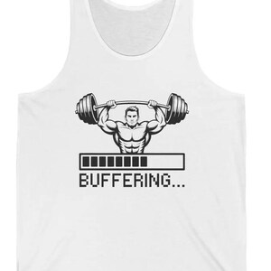 May include: White vest top featuring a black and white illustration of a weightlifter with a barbell. The design includes a loading bar and the text "BUFFERING...".