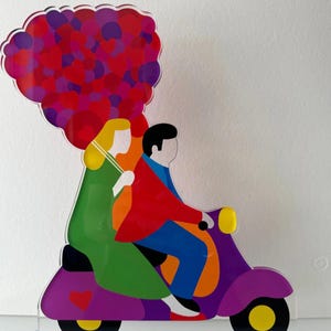 May include: A purple scooter with a couple riding on it. The woman is holding a bouquet of red and purple hearts. The scooter has a yellow headlight and yellow wheels.