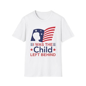 May include: White t-shirt featuring a patriotic design. The graphic includes a silhouette, stars, and stripes resembling the American flag, with the text "I WAS THE CHILD LEFT BEHIND" in red and blue.
