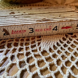 May include: A white wooden folding ruler with red markings and the text "LUFKIN RED END" on the side. The ruler is marked with numbers 2, 3, 4, and 5.