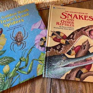 May include: Two vintage Golden Books: "The Golden Book of Insects and Spiders" with a butterfly, spider, and praying mantis illustration, and "The Golden Book of Snakes and Other Reptiles" featuring a snake and crocodile.