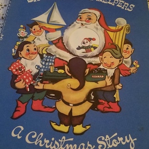 May include: A vintage children's book titled "Santa's Little Helpers: A Christmas Story" with a blue cover and illustrations of Santa Claus and elves. The elves are wearing red and green clothing and are holding toys.