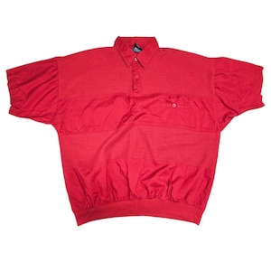 May include: A bright red polo shirt with short sleeves. The shirt features a collared neckline, a three-button placket, and a small pocket on the chest. The design includes horizontal ribbed and smooth panels, and a ribbed hem.