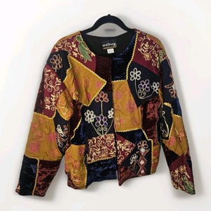 May include: A patchwork jacket with a variety of colors including burgundy, mustard yellow, navy blue, and black. The jacket features floral embroidery and a velvet texture. The label reads "wilroy LIMITED EDITION".