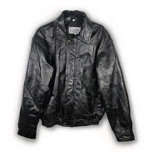 Puede incluir: Chaqueta de cuero negra con diseño de patchwork. La chaqueta tiene cuello, cierre de botón y una etiqueta "Cellini". Estilo bomber con puños y dobladillo elásticos.