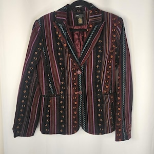 May include: A patterned blazer with vertical stripes in burgundy, black, and orange. The blazer has a two-button closure, two front pockets, and a notched lapel. The lining is a solid burgundy color.