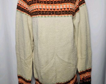 May include: Cream-colored sweater with a brown, orange, and white patterned yoke and cuffs. The sweater has a crew neck and long sleeves. The bottom hem and cuffs are dark brown. The sweater is displayed on a black mannequin.