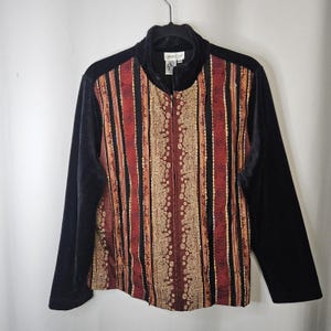 May include: A black zip-up jacket with long sleeves. The jacket features a high collar and a patterned front with vertical stripes in red, tan, and black. The sleeves and collar are solid black.