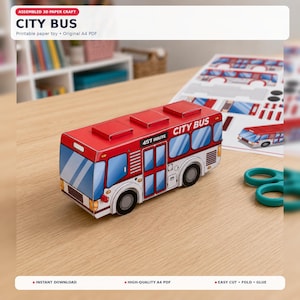 Puede incluir: Un juguete de autobús urbano de papel 3D ensamblado en rojo y blanco con ventanas azules. El lateral del autobús muestra el texto CITY BUS y 457 ROUTE. Una hoja de papel impresa con componentes del autobús y unas tijeras verde azulado.