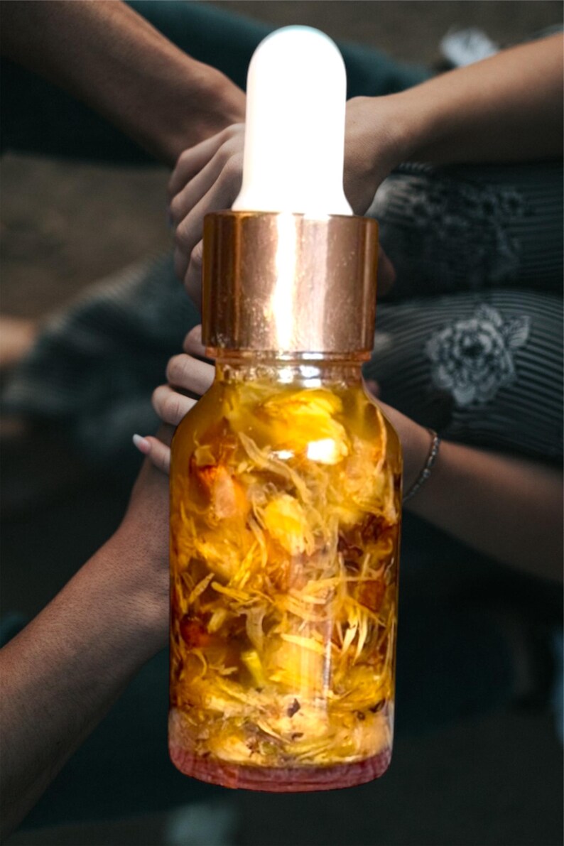 Puede incluir: Una botella de vidrio con tapa dorada y un gotero blanco llena de un l&iacute;quido amarillo y flores amarillas secas.