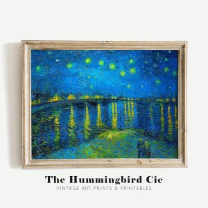 May include: A painting of a starry night sky over a river with a town in the distance. The water is reflecting the lights of the town and the stars. The painting is in a wooden frame.