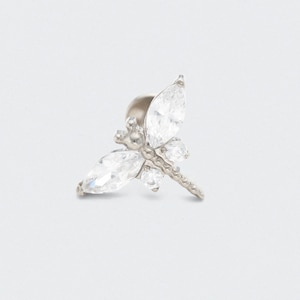 May include: A silver dragonfly stud earring with clear, sparkling crystals. The dragonfly design features two large, marquise-cut crystals for the wings and smaller crystals for the body. The earring post is visible.