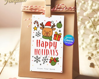 Può includere: Un sacchetto regalo di carta marrone con un'etichetta che recita "Happy Holidays". L'etichetta presenta una renna dei cartoni animati con un cappello di Babbo Natale, circondata da illustrazioni festive. L'etichetta è tenuta da una molletta di legno con spago rosso e bianco.