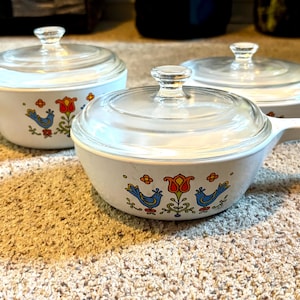 May include: A set of three ceramic mugs with a speckled, matte finish. The mugs are in shades of cream, light gray, and dark gray. Each mug has a simple, minimalist design, perfect for coffee or tea.
