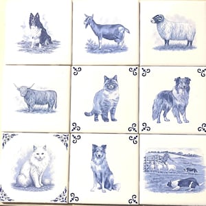 May include: A set of nine square ceramic tiles arranged in a grid, each featuring blue ink illustrations on a white background. The tiles depict various animals including dogs, cats, a goat, a sheep, and a highland cow, with some tiles featuring decorative corner flourishes.