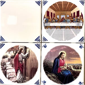 May include: Set of four square ceramic tiles. Three tiles feature religious scenes: The Last Supper, Jesus knocking on a door, and Jesus with a lamb. The fourth tile is blank. Each tile has blue corner designs.