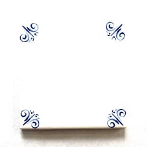May include: A square, white ceramic tile with a decorative blue floral design in each corner. The design features a series of swirls and dots. The tile is likely for use in a kitchen or bathroom.