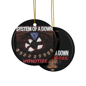 May include: A round ceramic ornament featuring the System of a Down album cover for "Hypnotize". The album cover is a black and red design with a blue-faced figure in the center. The text "System of a Down" and "Hypnotize" are printed in white.