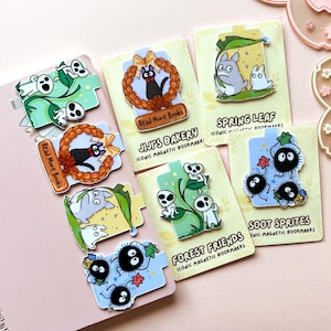 Puede incluir: Una colecci&oacute;n de marcadores magn&eacute;ticos ic&oacute;nicos con varios personajes de anime. Los dise&ntilde;os incluyen un gato negro en una corona, esp&iacute;ritus del bosque, duendes de holl&iacute;n y Totoro con una hoja. Cada marcador tiene un dise&ntilde;o &uacute;nico y el texto "Read More Books".
