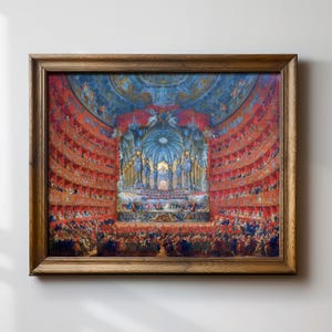 May include: A framed painting depicting a grand opera house interior. The stage is adorned with ornate decorations and a large, colorful ceiling. The audience is seated in red velvet boxes, and the stage is filled with musicians and singers.