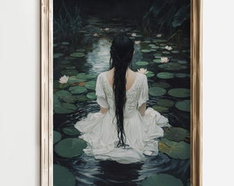 May include: A framed art print depicts a person with long black hair in a white dress, seated in a pond surrounded by lily pads and white flowers. The artwork has a serene, ethereal quality, with a wooden frame.
