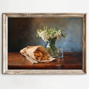 May include: A framed still life painting featuring a brown paper bag overflowing with golden french fries. A glass vase holds white flowers, and a small glass jar sits nearby. The scene is set on a dark wooden table.