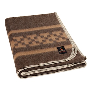 Peut inclure: Une couverture en laine d'alpaga marron avec un motif à carreaux brun et beige et une bordure beige. La couverture est pliée et porte une étiquette blanche avec le texte "Alpaca Warehouse".
