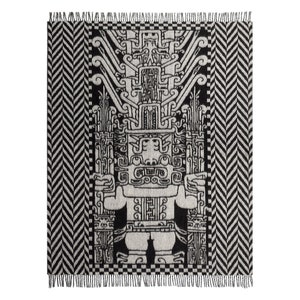 May include: Black and white woven throw blanket with a geometric design featuring a stylised figure with a large head and intricate details. The blanket has a fringe border.