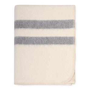 May include: A white wool blanket with two grey stripes. The blanket has a soft, fuzzy texture.
