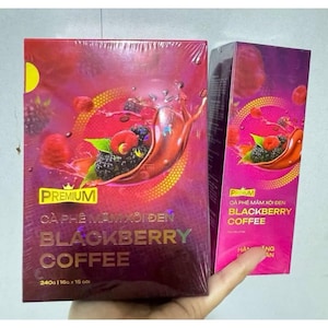 May include: A box of premium blackberry coffee with a red and purple design. The box features a picture of blackberries and raspberries in a red liquid. The text on the box reads "Premium Ca Phe Mam Xoi Den Blackberry Coffee 240g | 16g x 15 goi".