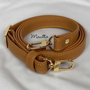 Tan leather strap with accent yellow/gold stitching. Adjustable configuration for shoulder to cross body lengths.
